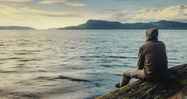 Survival Skills: Why you should STOP! Man sitting on a log watching the forest to Stop Think Observe and Plan. - StayWild Outdoor